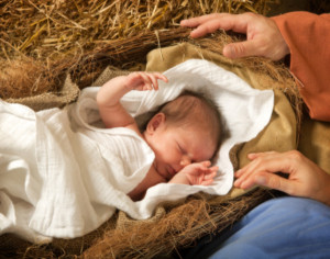 20 days old baby sleeping in a christmas nativity crib